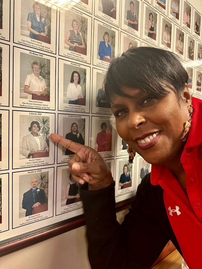 Dr. Rachel Alex pointing to her photo on a wall of recognition