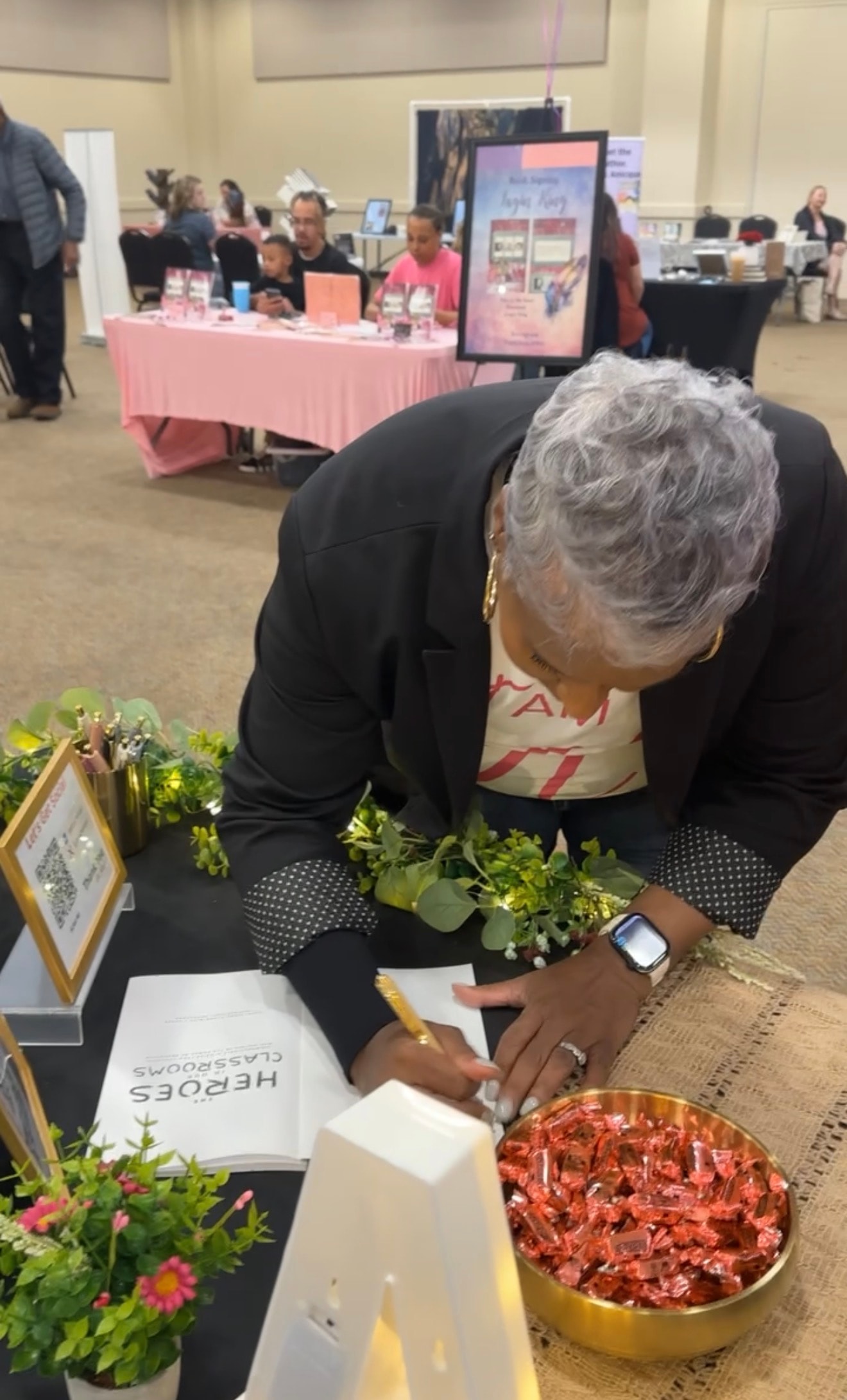 Dr. Rachel Alex signing books at a community event