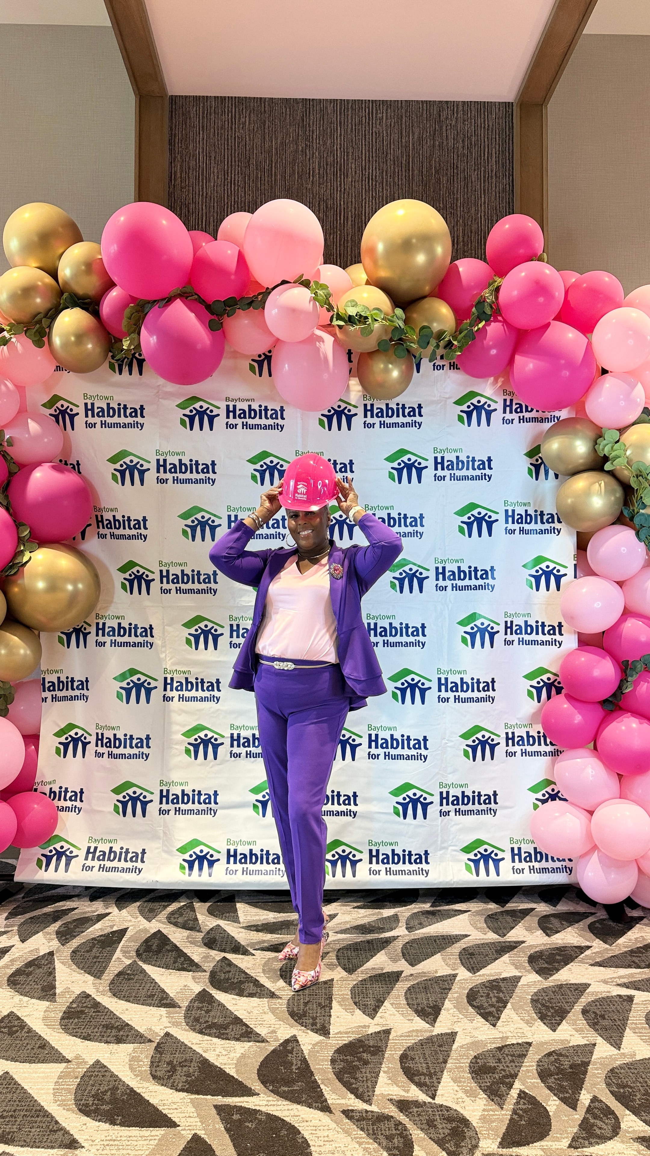 Dr. Rachel Alex at Baytown Habitat for Humanity event in purple suit with pink hard hat