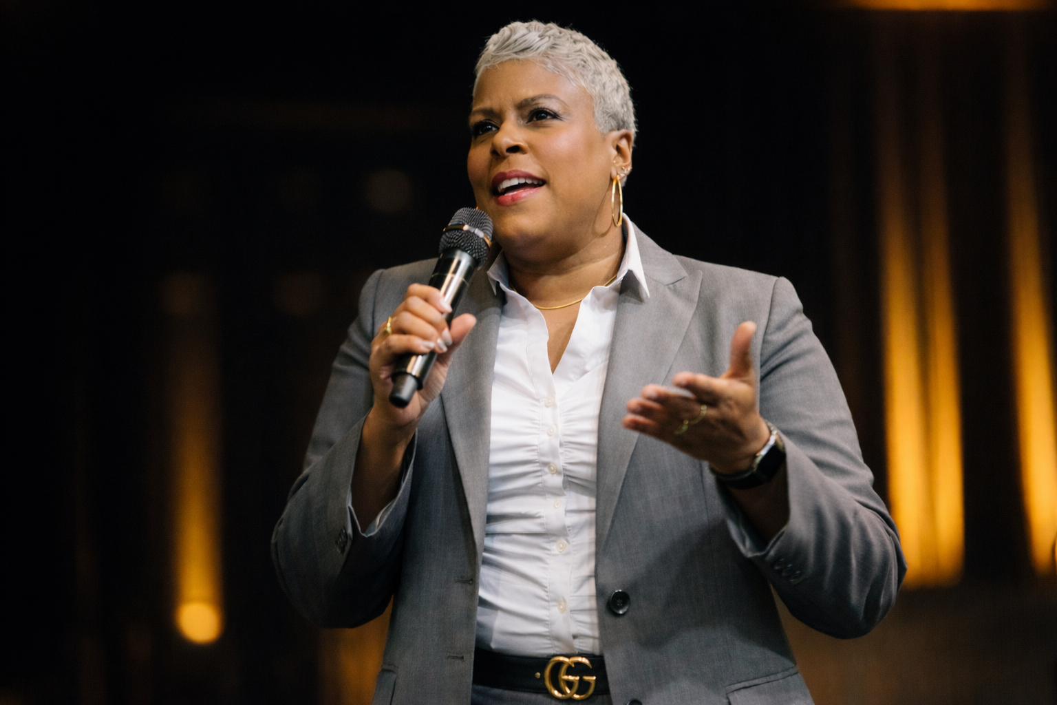 Dr. Rachel Alex speaking on stage with microphone